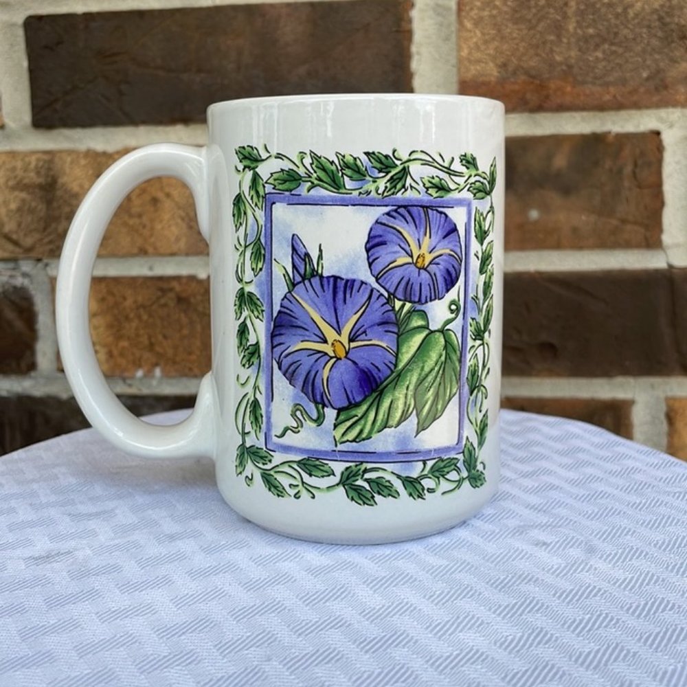 White Coffee Cup With Purple Flowers Painted On it.